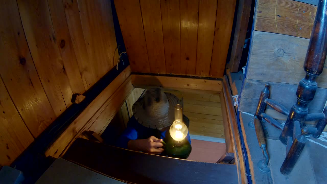 그 남자는 집의 두 번째 층으로 올라갑니다. 그의 손에는 오래된 석유 램프와 도끼가 있습니다.