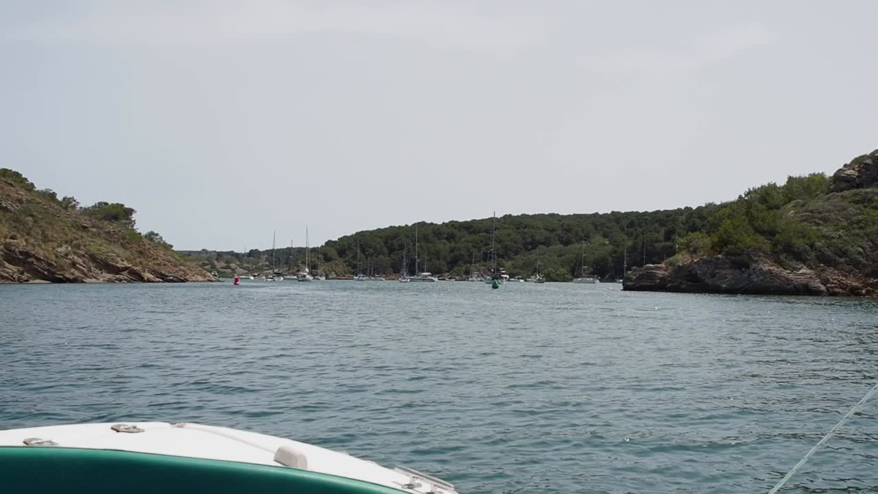 Viaggio in barca attraverso Port D'Addaia, Minorca, con vista panoramica su yacht e costa.