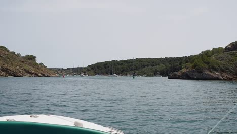 boat journey through port d'addaia menorca with scenic view of yachts and coastline