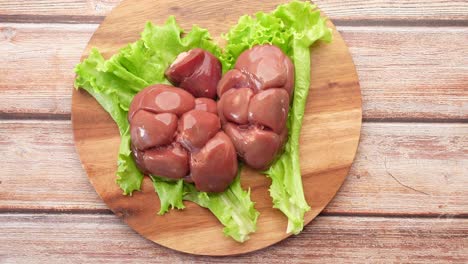 raw fresh lamb kidneys on a chopping board ,