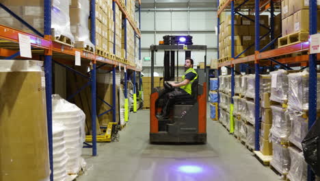 worker driving electric forklift inside a warehouse , logistic distribution industrial interior