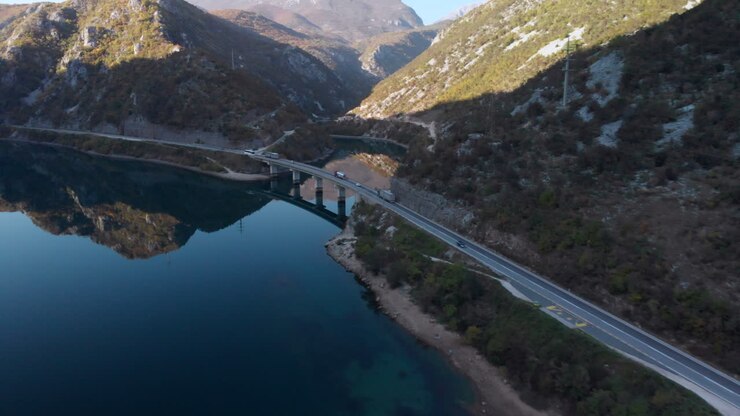 Ponte stradale panoramico attraverso le montagne bosniache, il fiume Neretva, vista aerea.