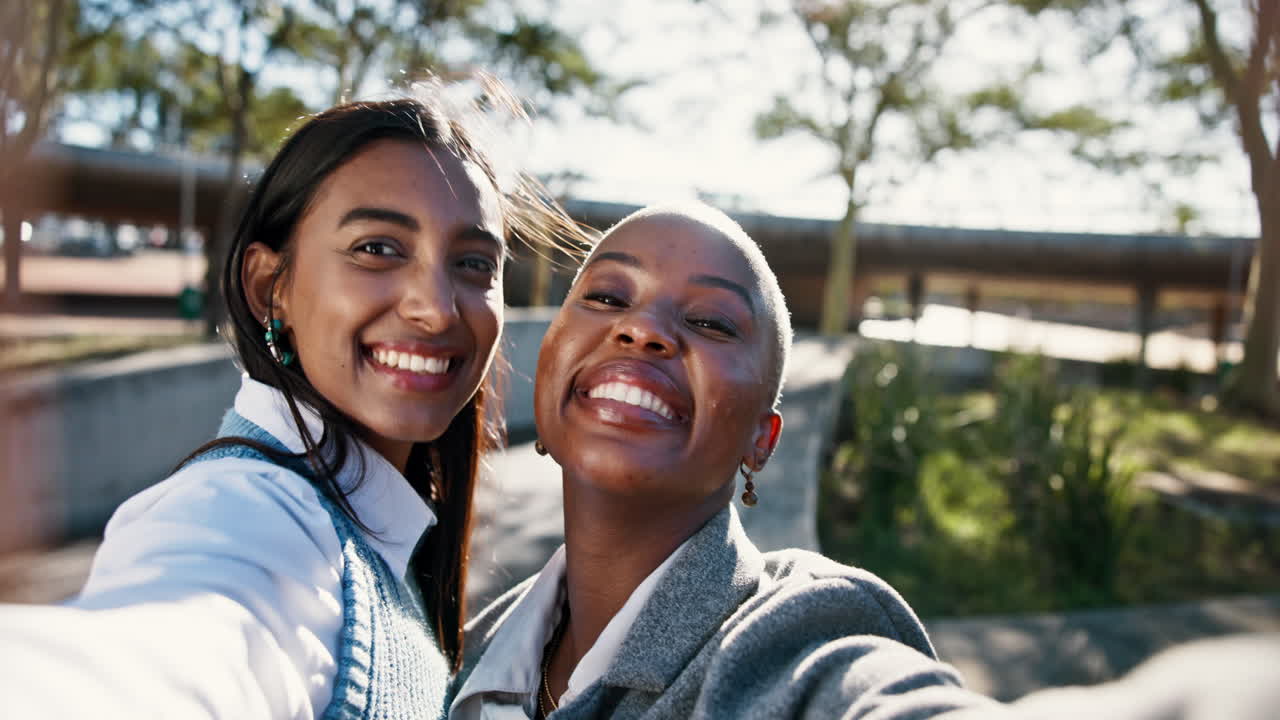 Two happy women taking a selfie outdoors