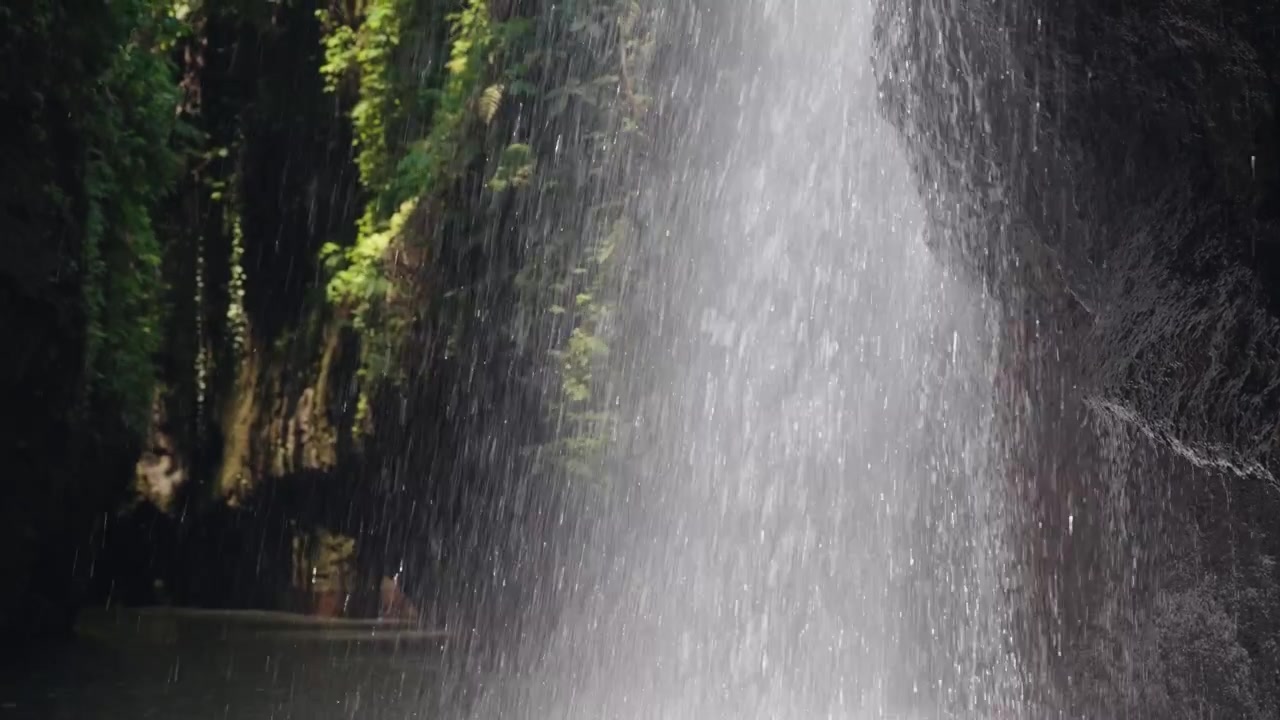 Close-up of Tropical Waterfall Cascading Down Rocky Cliff