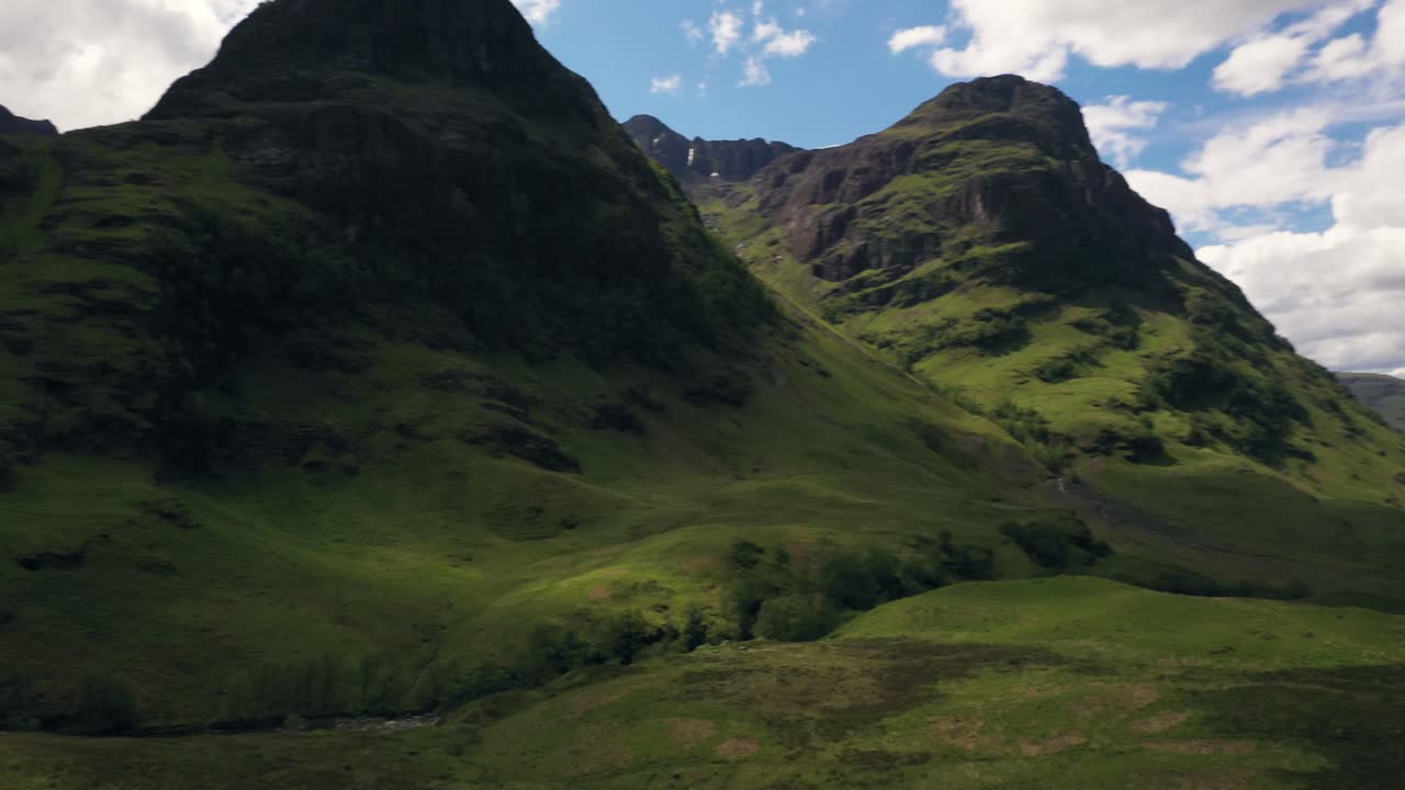 A cinematic panning shot in the middle of a majestic mountain valley, in the Highlands of Scotland | The Lost Valley, Glencoe, Scotland | Shot in 4k at 30 fps
