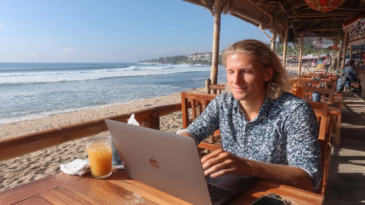 A Focused Individual Working on a Laptop While Enjoying a Beachside Setting with Relaxing Waves and Natural Light Enhancing the Serene Atmosphere