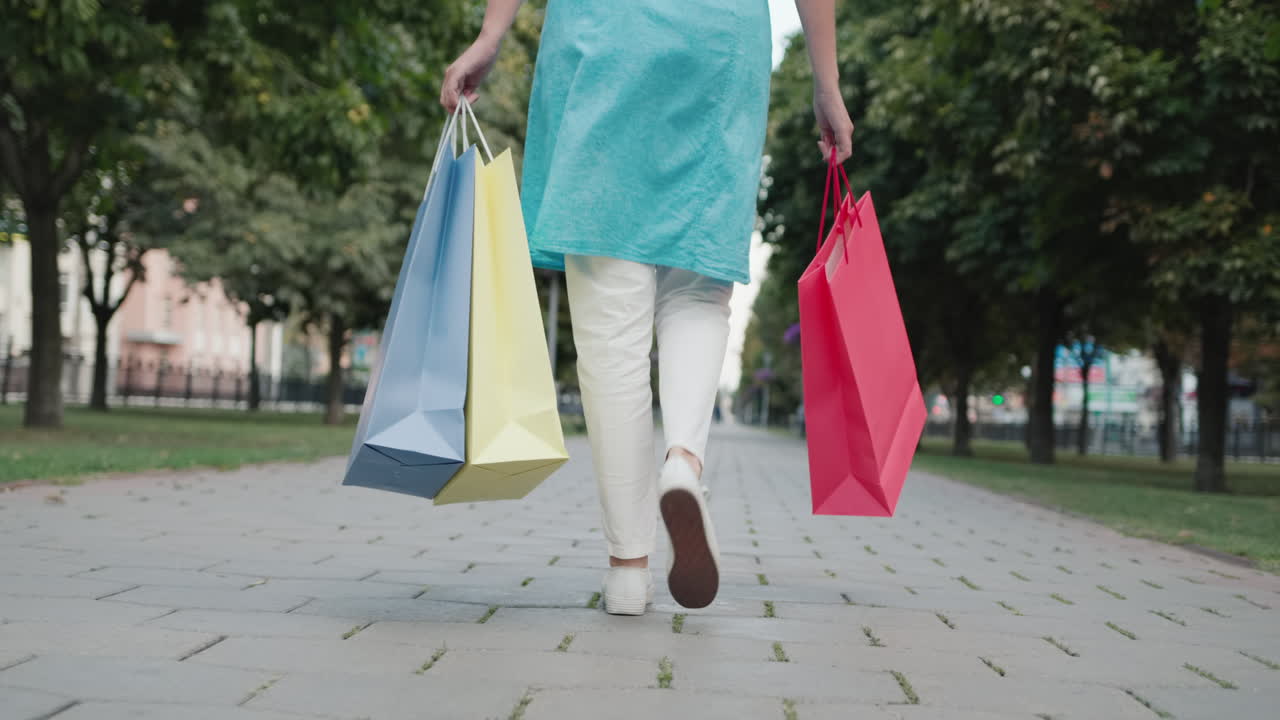 한 젊은 여성이 패션 매장에서 쇼핑백을 들고 다닌다