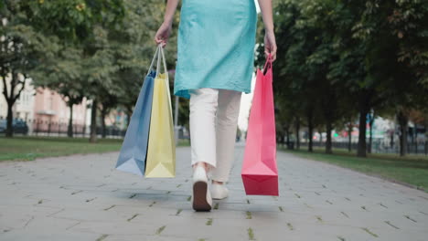 una mujer joven lleva bolsas de compras de las tiendas de moda