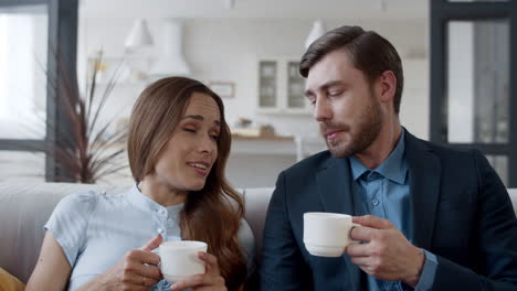 una pareja feliz bebiendo té en casa.