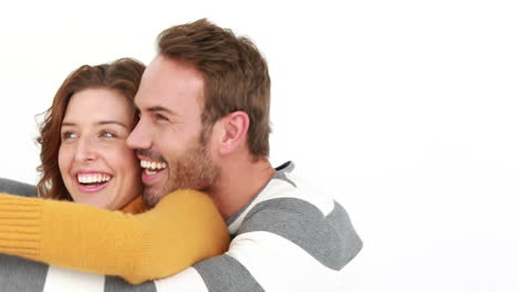 una pareja sonriente abrazándose en un fondo blanco