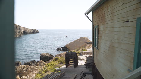 rundown wooden house terrace with a keg in a holder,rocky sea shore