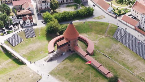 Kaunas castle tower and waving flag, aerial drone high-angle view