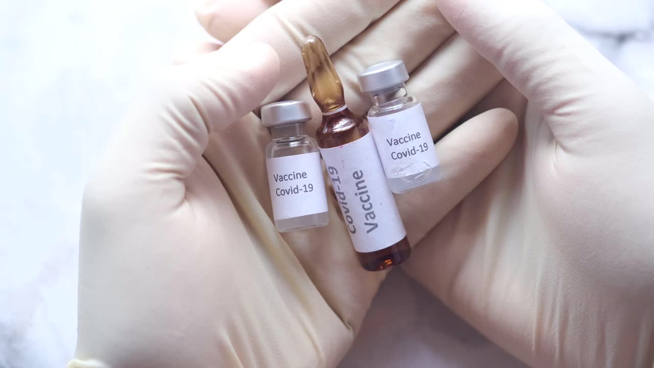 viales de vacuna contra la covid-19 en las manos