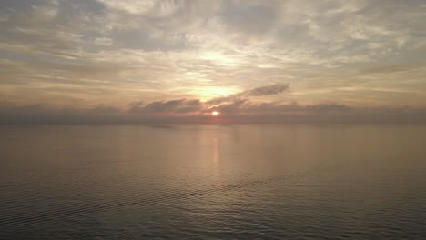 beautiful golden cloudy sunrise on ocean horizon, calm and peaceful