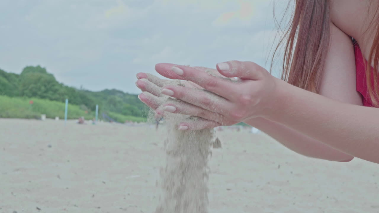 Woman with bikini on beach playing with sand,close up