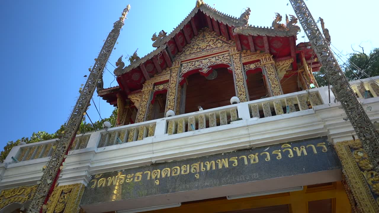 Incredible Wat entrance with very detailed carvings and colorful items in a Buddhist Temple in Chiang Mai, Thailand.