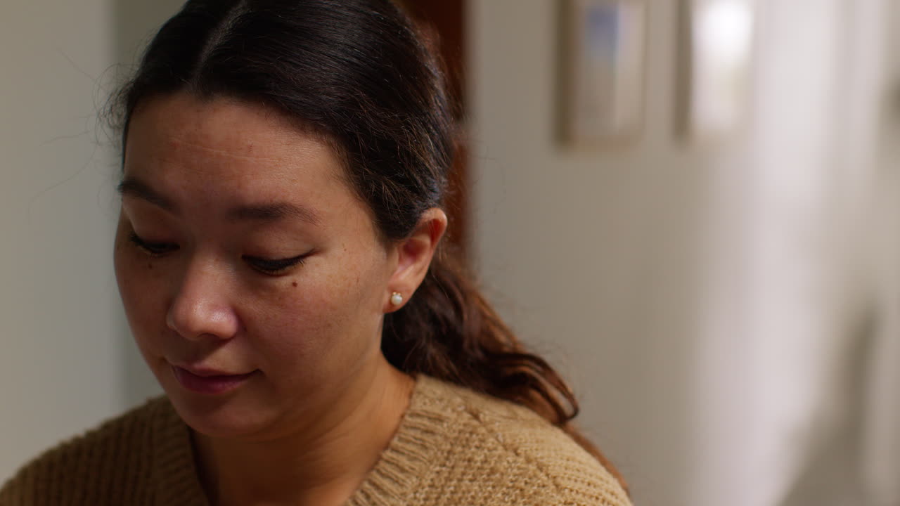 Head And Shoulders Shot Of Woman At Home Working In In Kitchen Preparing Healthy Meal