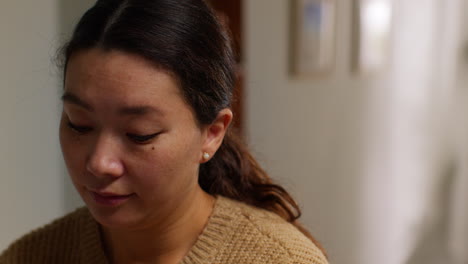 head and shoulders shot of woman at home working in in kitchen preparing healthy meal