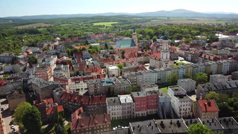 Historic-buildings-with-red-rooftops,-lush-greenery,-and-the-surrounding-scenic-countryside-with-distant-hills