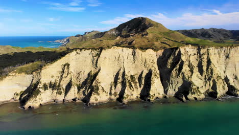 Aerial-View-Of-Rugged-Cliff-Of-Cooks-Cove-On-A-Sunny-Summer-Day-Near-Tolaga-Bay-In-New-Zealand
