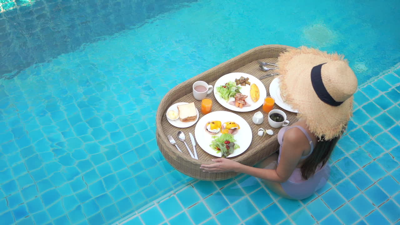 Woman enjoying floating breakfast in swimming pool