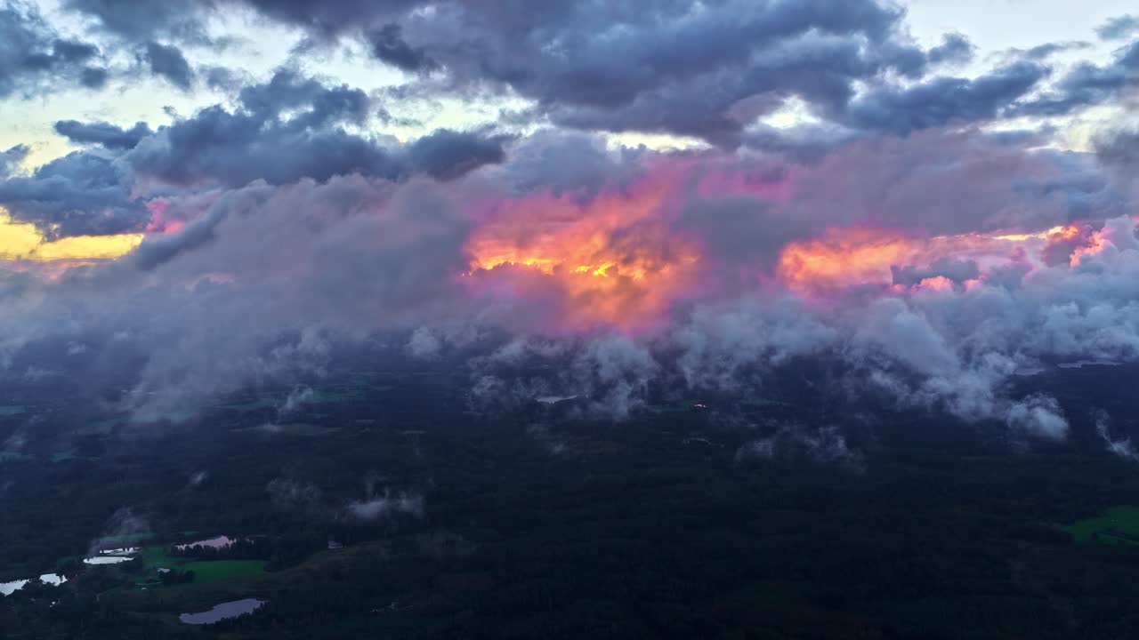 Aerial: sea of fog in the clouds at high altitude at sunset with golden hour colors, crane up drone shot