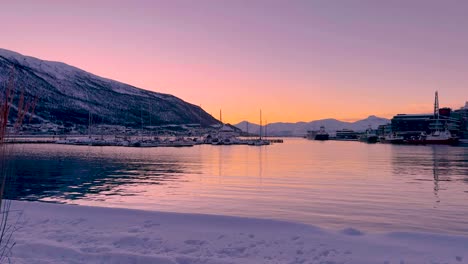 Panning-shot-of-buildings-and-water-at-Tromso-Noway,-with-snow-on-the-the-ground