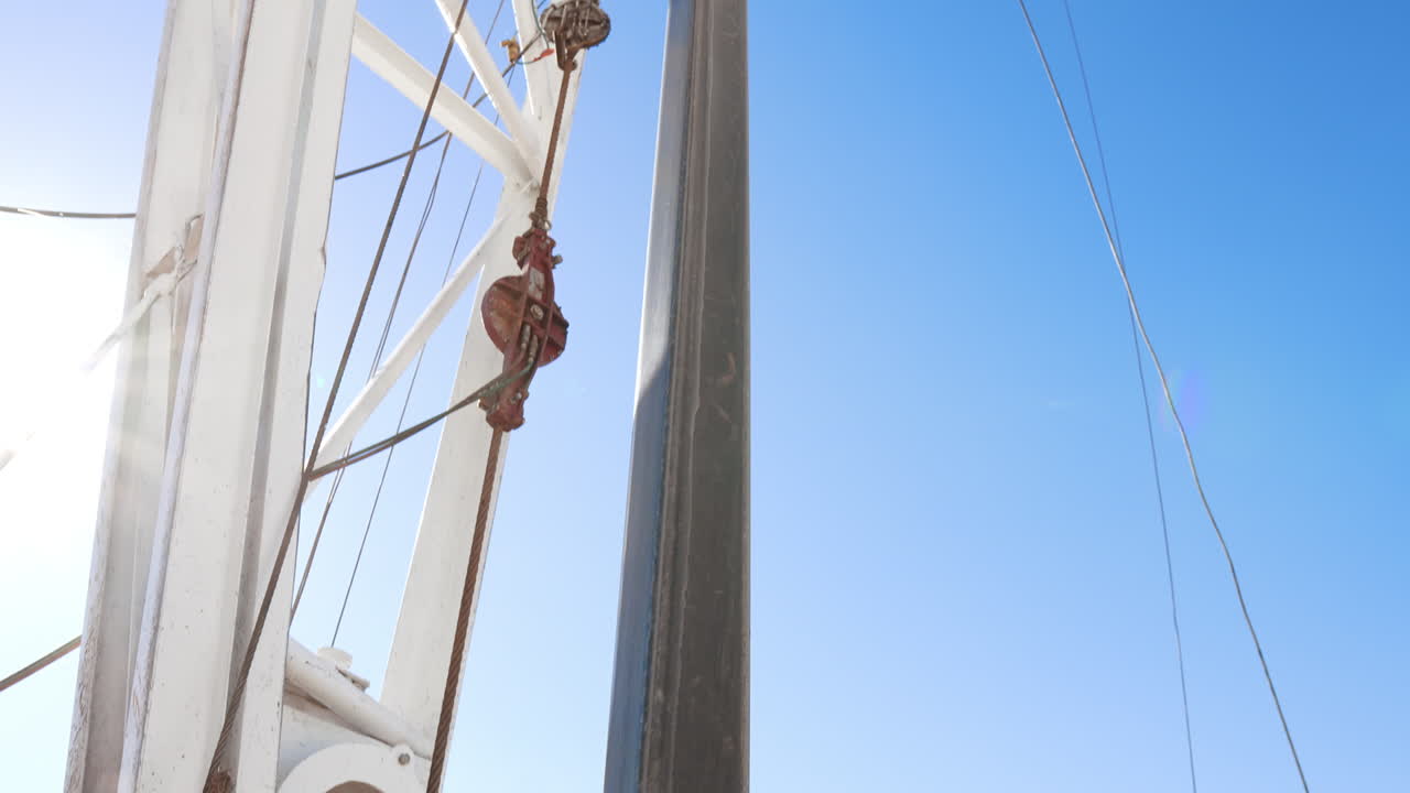 Rotary equipment working at the site for oil or gas production. Low angle view at the derrick for natural resources boring.
