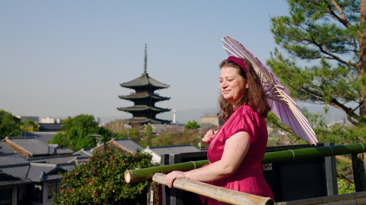 una mujer europea con un paraguas japonés tradicional en el punto de vista de la pagoda yasaka en kioto, japón