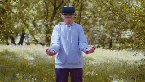 Senior-man-exercising,-making-dumbbell-weight-lifting-exercises,-wearing-VR-helmet-play-video-game