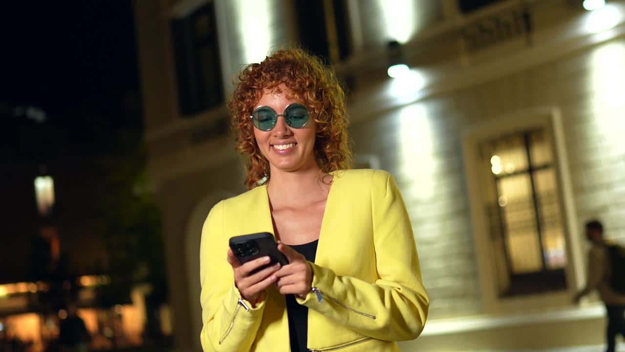 Donna con i capelli ricci che usa il telefono di notte