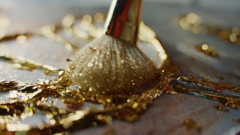 applying gold leaf with a brush