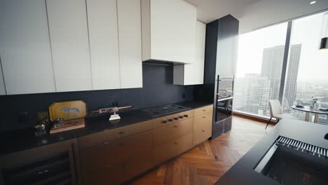 luxury kitchen with dark wood and black accents with white cabinets in a luxury condo building, wide push in