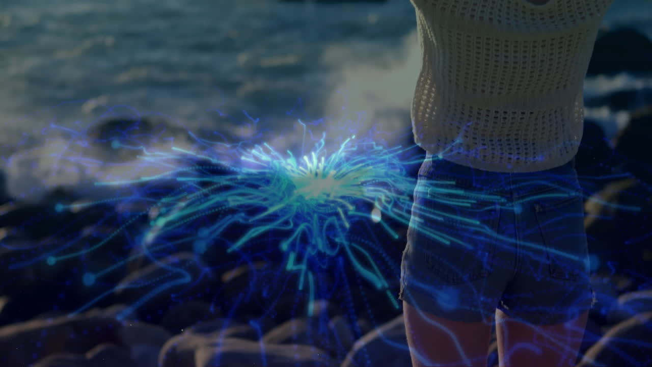 Person standing by ocean with blue energy animation radiating outward