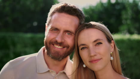 portrait of attractive woman and handsome man smiling at camera outdoors