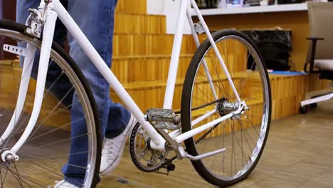 low-section of business executive walking with bicycle