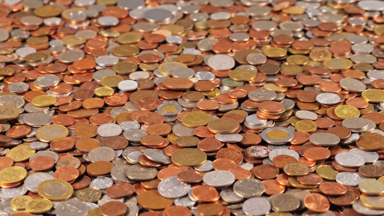 Coins of different sizes and colors spread across a flat surface