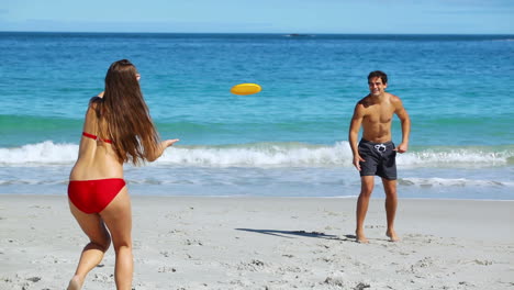 una pareja feliz jugando al frisbee.