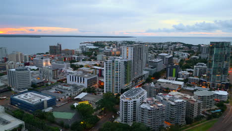 Drone-Aéreo-De-La-Ciudad-De-Darwin-Cbd-Australia-Nt-Orbita-Alrededor-De-Edificios-Con-Puesta-De-Sol-Brillando-En-El-Cielo