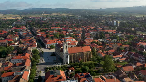 Cinematic-rotating-drone-shot-of-buildings-and-city-streets-of-Keszthely-in-Hungary