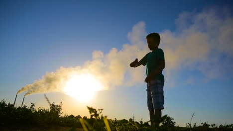 kid playing with paper airplane. happy kid playing with paper airplane in the sunset near air pollution
