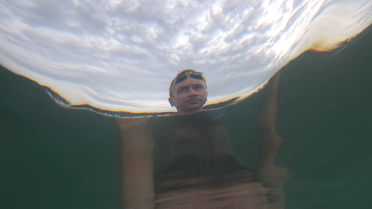 Vista subacquea che guarda verso l'alto la silhouette di un nuotatore distorta dalla superficie increspata, Golfe-Juan, Francia