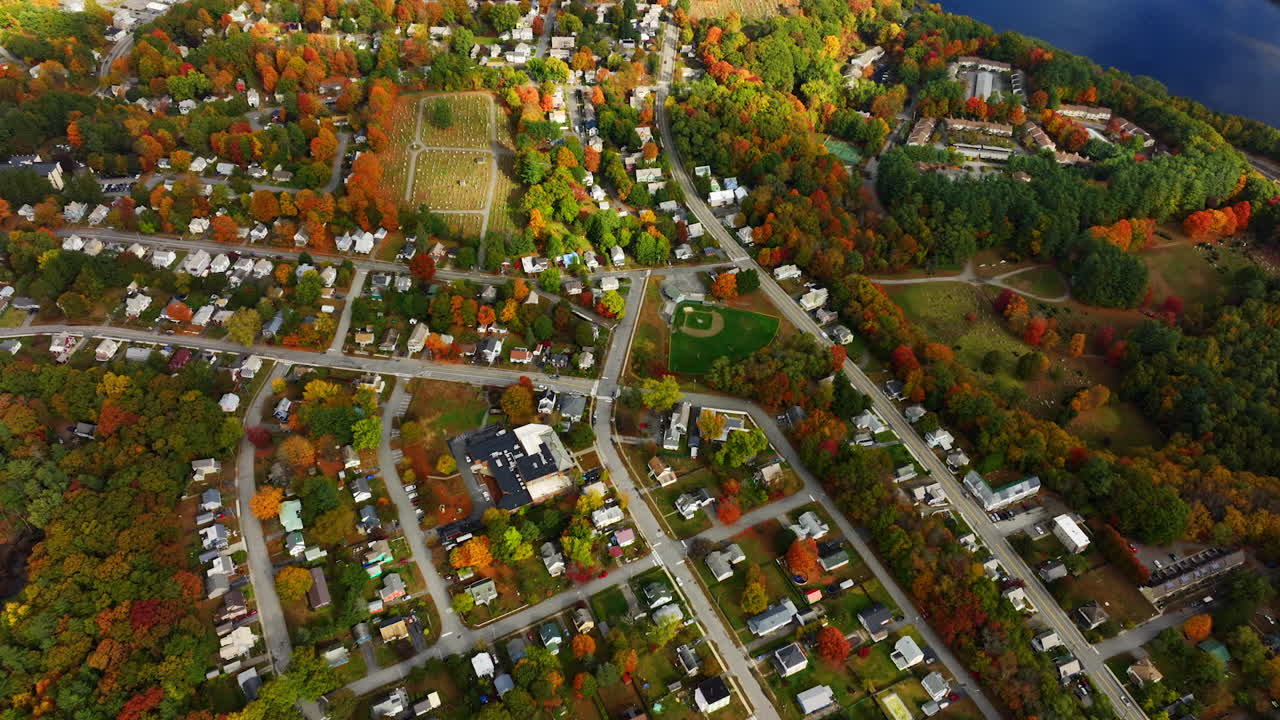 Urban landscape beautifully combined with picturesque nature locating on the waterfront of the river. Top view on Vermont, New England, USA in autumn.