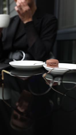 woman enjoying coffee and macarons outdoors