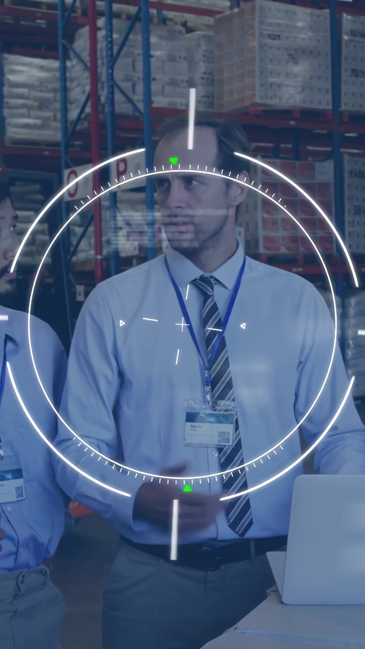 Video verticale: Capo che indica vicino a un laptop in magazzino, HUD che anima il busto e contrassegna i pallet per la verifica.