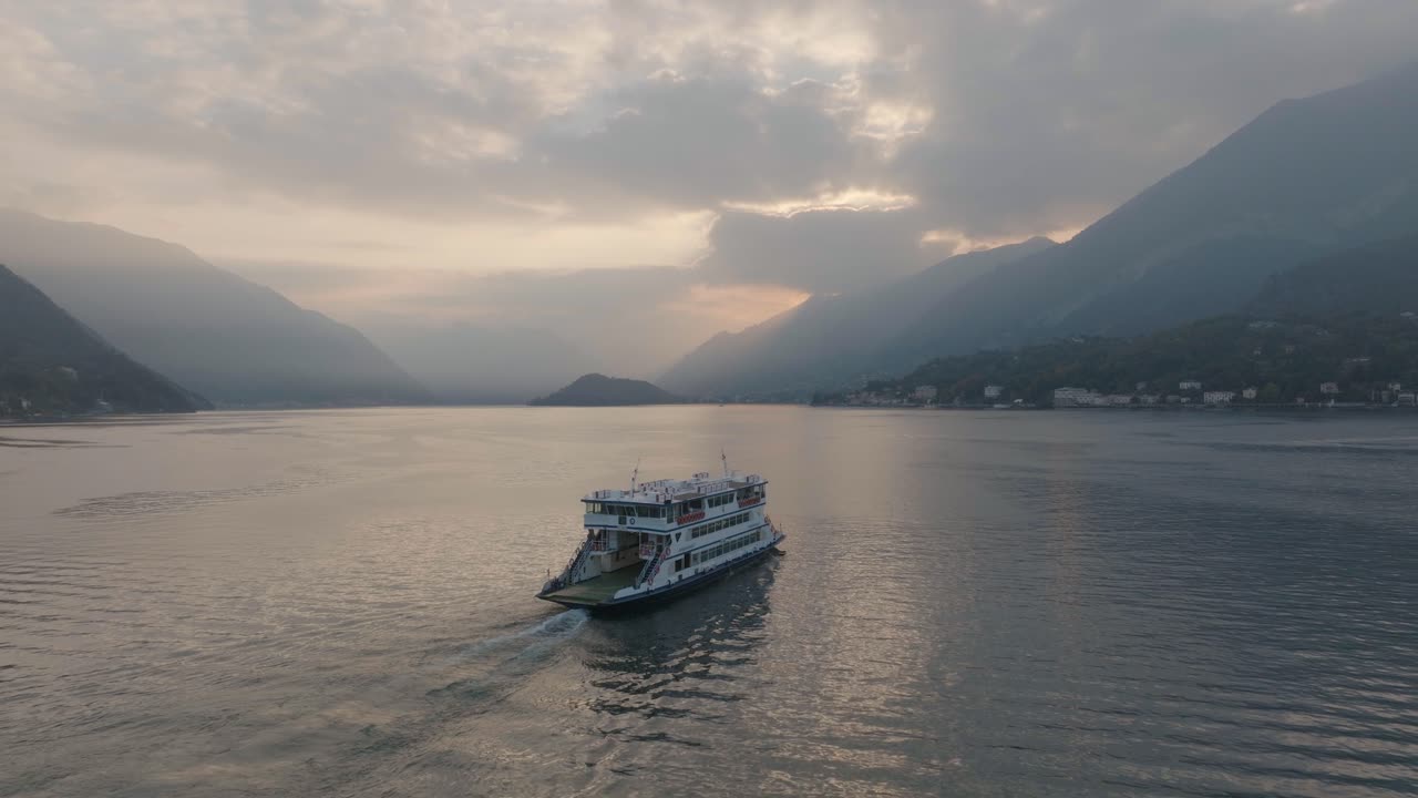antena 4k - puesta de sol lentamente siguiendo un ferry en el lago de como, italia