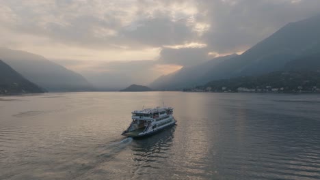 Antena-4k---Puesta-De-Sol-Lentamente-Siguiendo-Un-Ferry-En-El-Lago-De-Como,-Italia