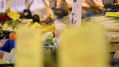 an assortment of fresh colorful vegetables in the produce section of an outdoor market in hanau, germany - right panning shot