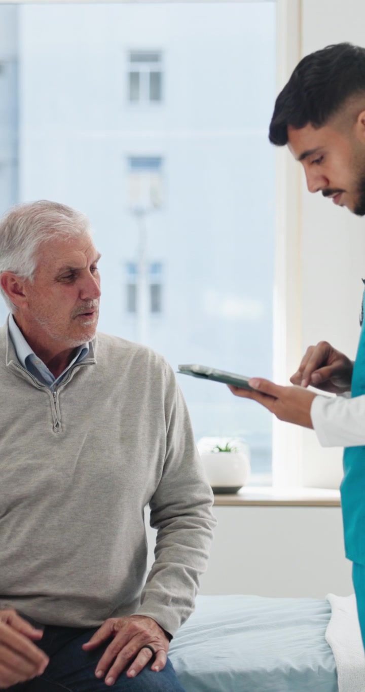 Læge konsulterer ældre patient på lægekontor