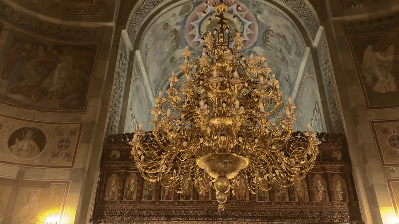Ornate golden chandelier under frescoed dome in Mihai Vodă Church Bucharest